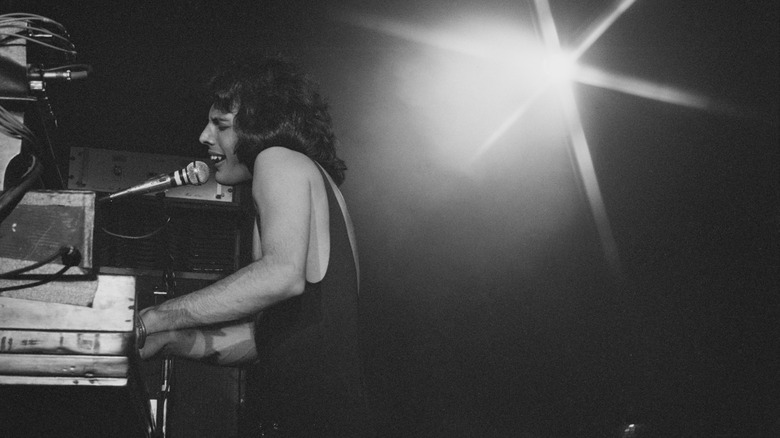 Freddie Mercury playing piano while singing