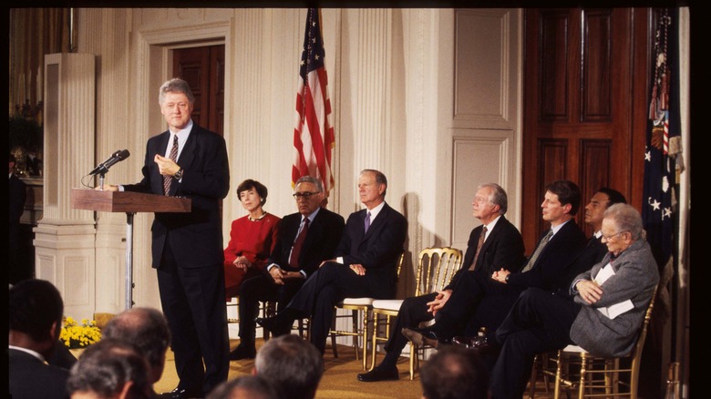 bill clinton on podium at NAFTA meeting crowd american flag