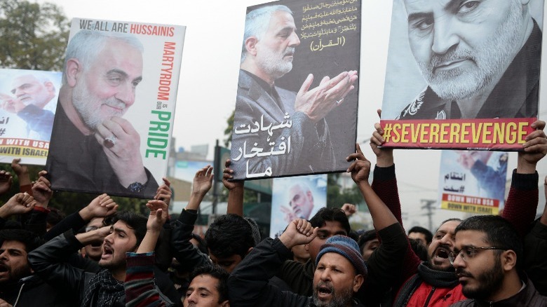 Iranians holding protest signs