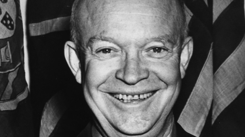Eisenhower smiling in front of American flag