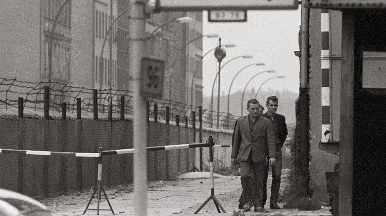 Germans standing alongside Berlin Wall