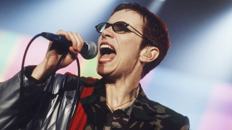 Annie Lennox singing on stage in sunglasses