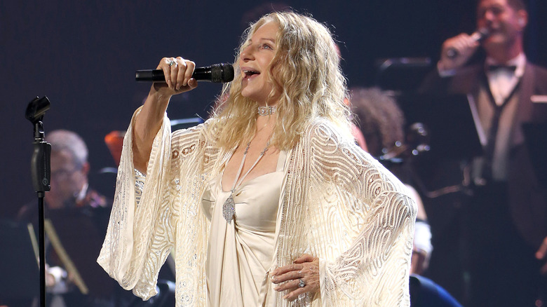 Barbra Streisand singing on stage in white dress