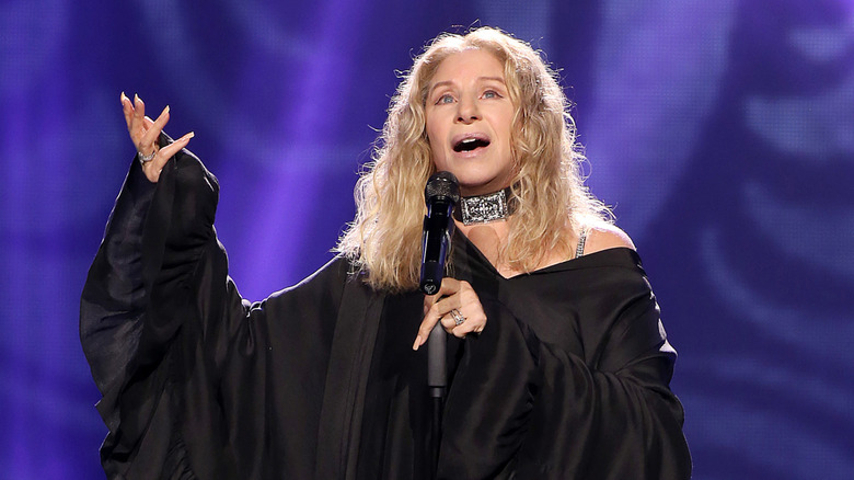 Barbra Streisand singing in black robe on stage