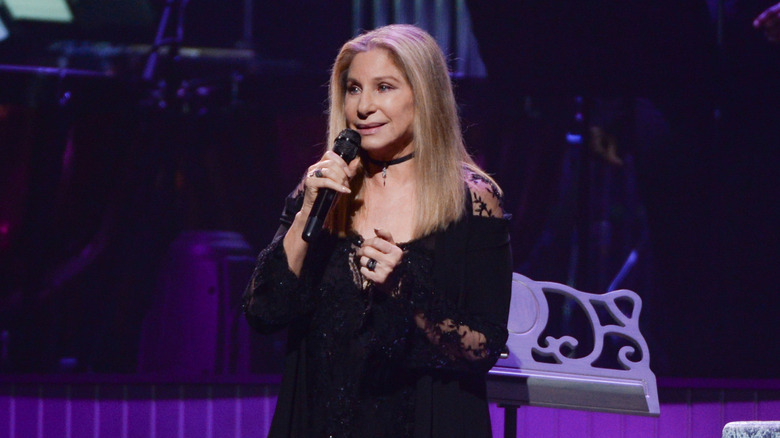 Barbra Streisand talking on stage in black dress