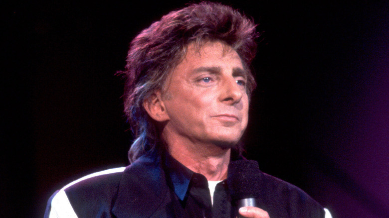 Barry Manilow stares from stage while holding microphone