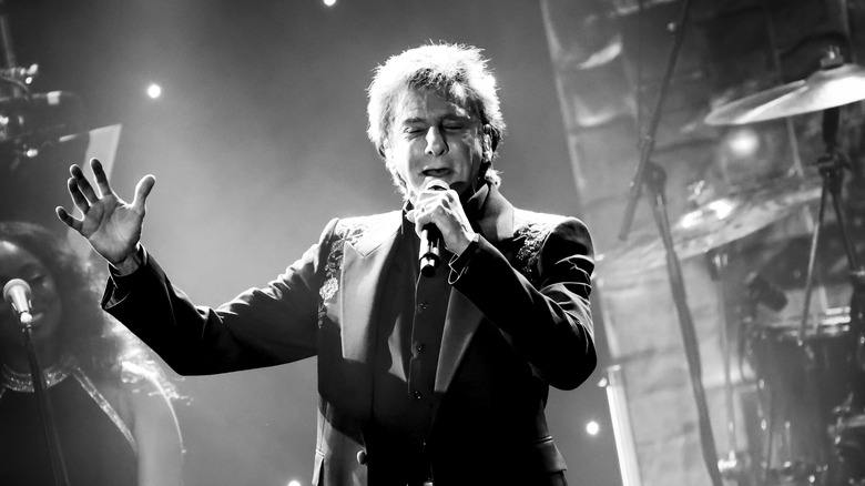 Barry Manilow performing with one arm raised