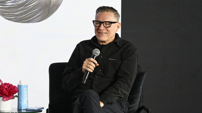 Bryan Adams holding a mic and smiling