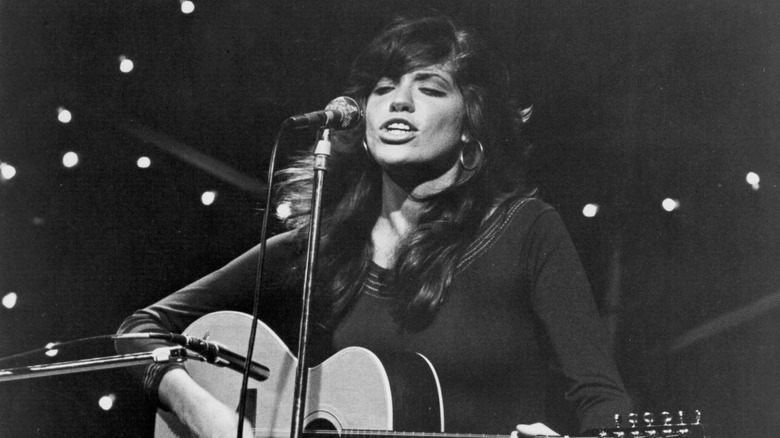 Carly Simon playing guitar and singing onstage in the '70s
