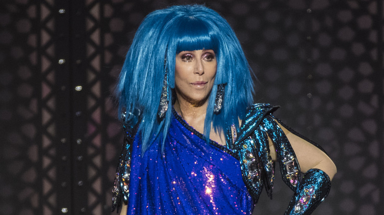 Cher wearing a blue wig on stage.