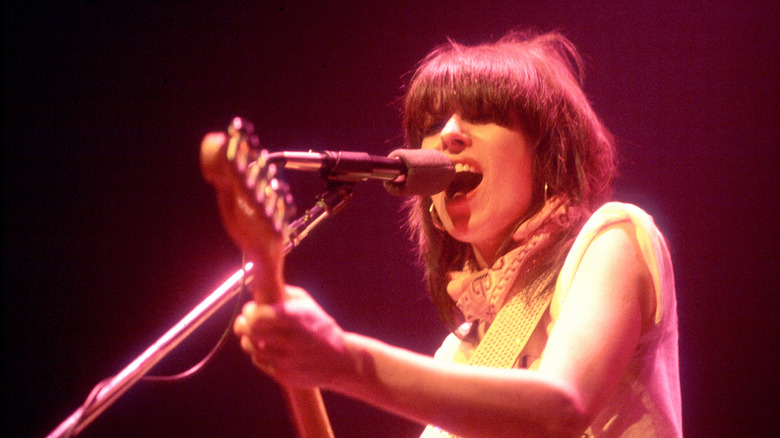 Chrissie Hynde with guitar and microphone