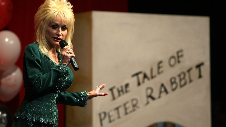 Dolly Parton on stage in front of large book display