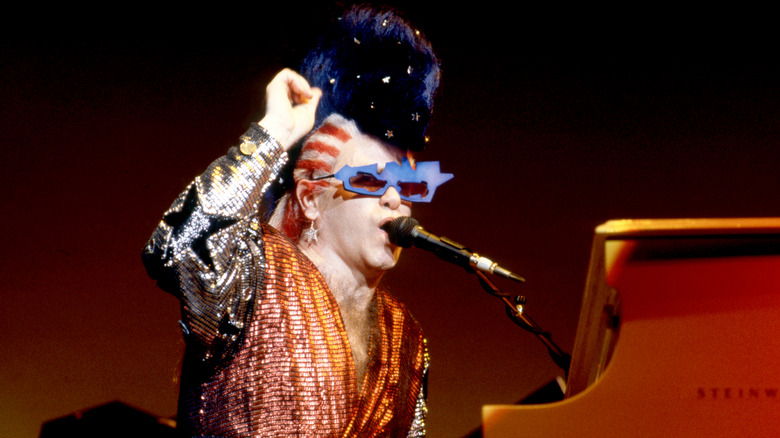 Elton John in costume at a piano on stage