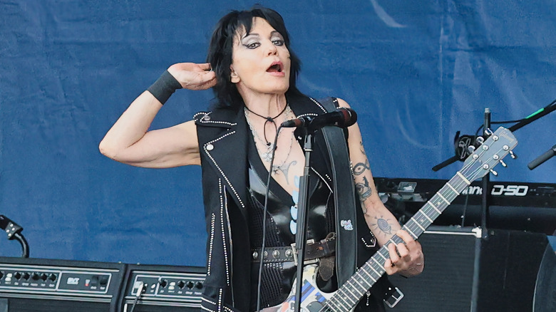 Joann Jett on stage with her guitar, interacting with the audience.