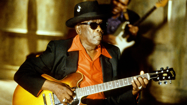 John Lee Hooker in hat and glasses with guitar