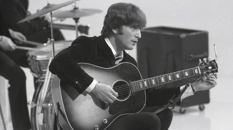 John Lennon tuning guitar while filming A Hard Day's Night at Scala Theatre