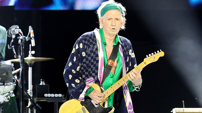 Keith Richards playing guitar on stage