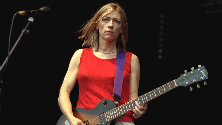 Kim Gordon playing guitar on stage