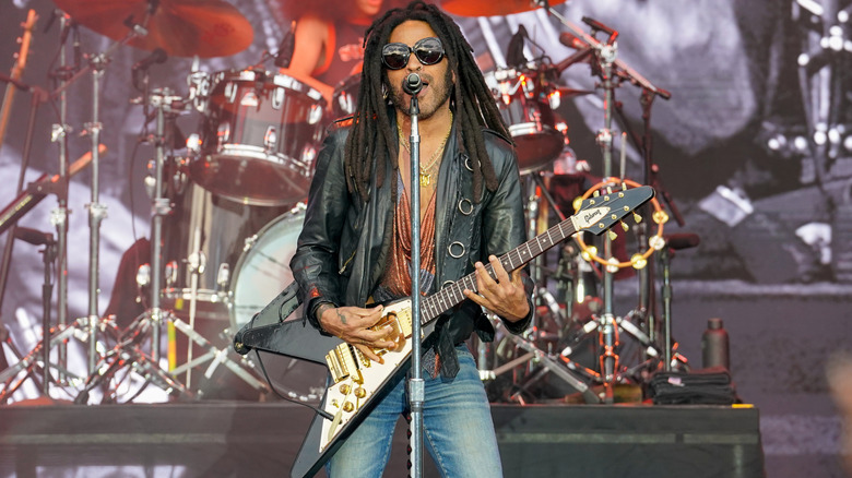 Lenny Kravitz singing and playing guitar on stage