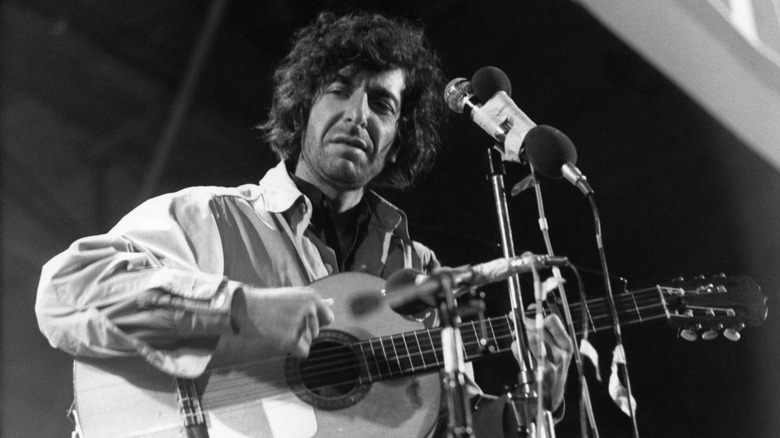 Leonard Cohen playing guitar on stage