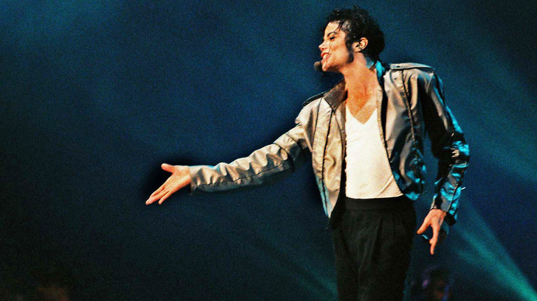 Michael Jackson onstage singing with arm outstretched in early '90s