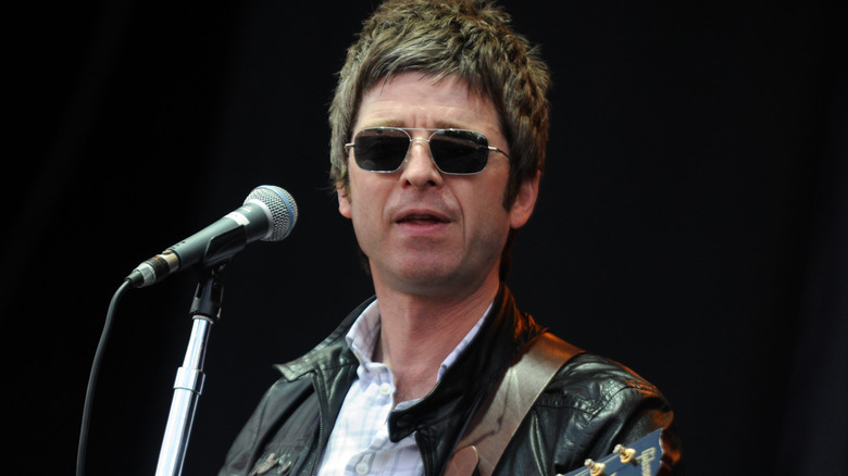 Noel Gallagher playing guitar onstage