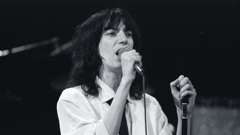 Patti Smith at microphone in white shirt