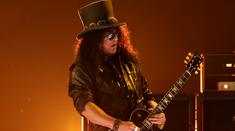 Slash on stage playing an electric guitar.