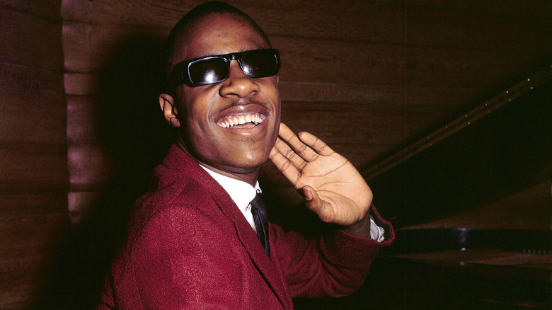 Stevie Wonder sat by piano in red suit