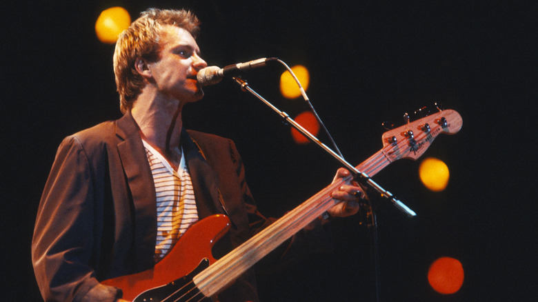 Sting on stage playing bass and singing