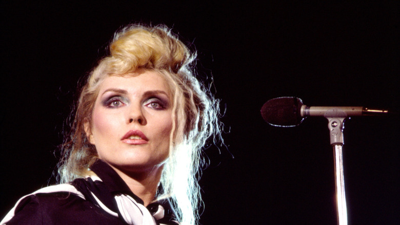 Debbie Harry staring ahead onstage beside microphone