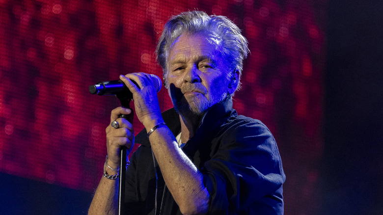 John Mellencamp holding a mic stand