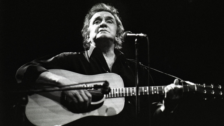 Johnny Cash with guitar on stage