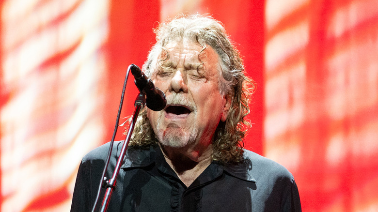 Robert Plant singing into a microphone onstage