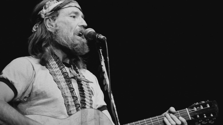 Willie Nelson singing and playing guitar