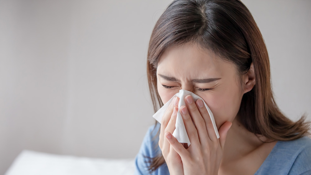 A woman sneezing