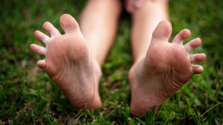A child spreading her toes sitting on grass