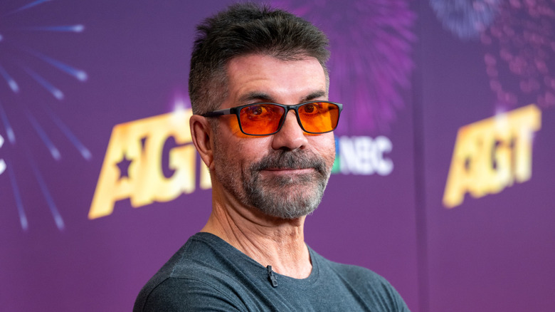 Simon Cowell wearing sunglasses and posing for a photo on the America's Got Talent red carpet