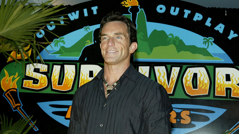 Jeff Probst in front of Survivor logo