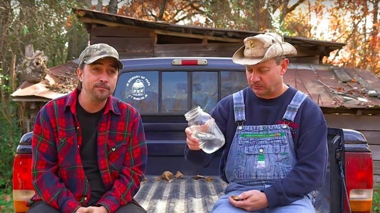 Moonshiners sitting truckbed drinking