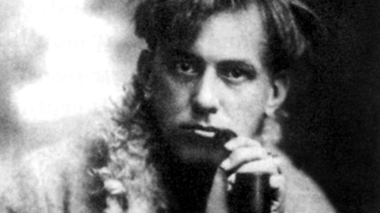 Aleister Crowley holding a pipe