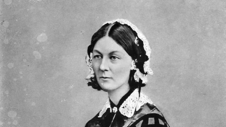Florence Nightingale standing with white lace headdress