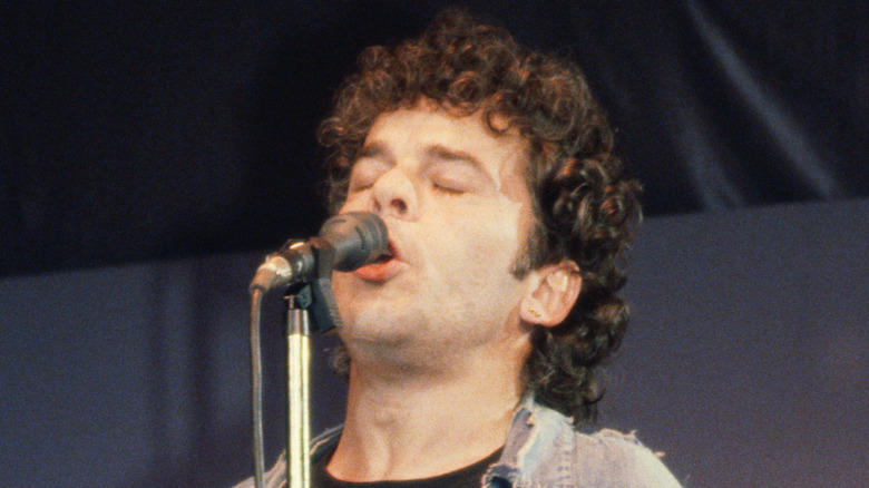 Ian Dury eyes closed singing into mic