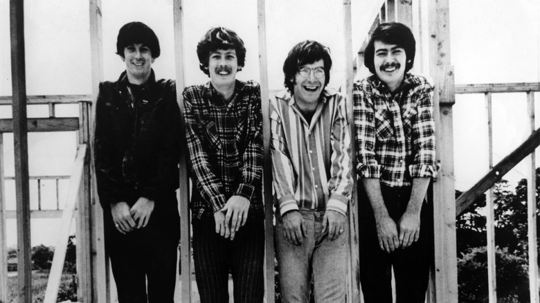 Lovin' Spoonful members squeezing between railing and smiling