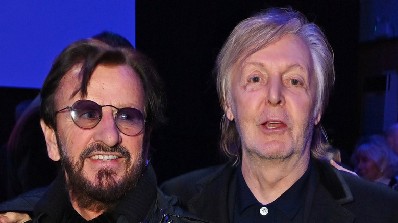 Ringo Starr grinning and looking past Paul McCartney