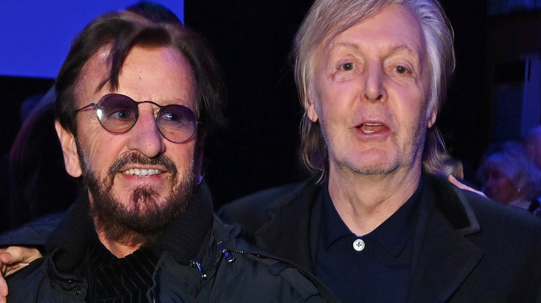 Ringo Starr grinning and looking past Paul McCartney