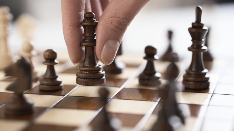 person moving a chess piece