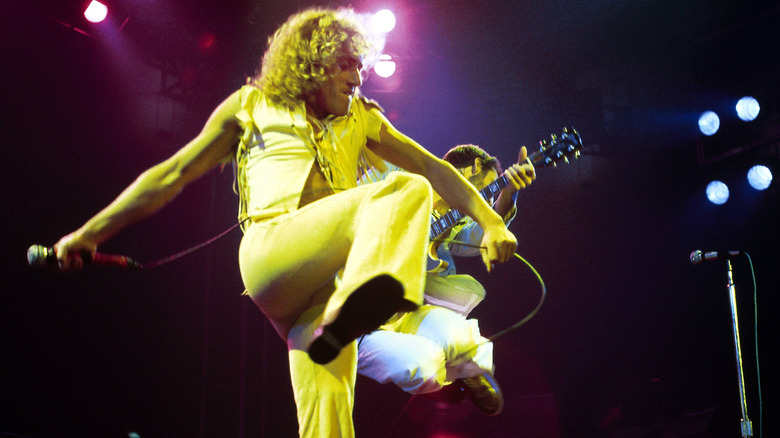 The Who's Roger Daltrey performing live while holding a microphone