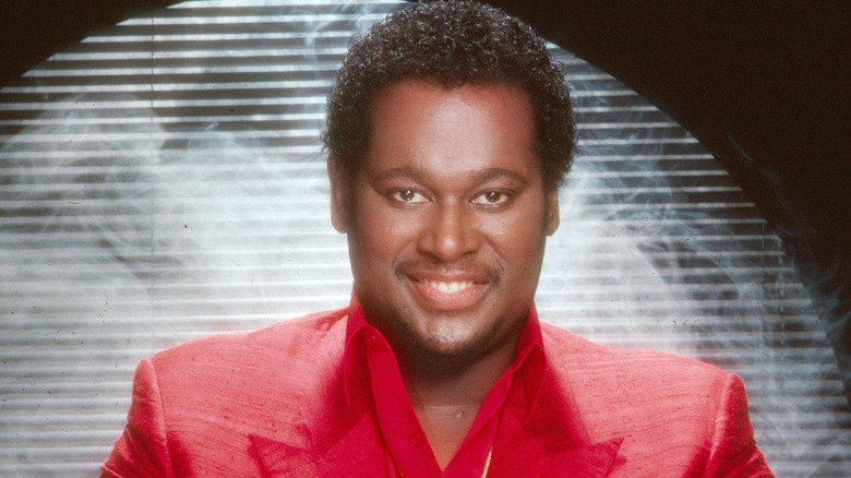 Luther Vandross smiling in a red suit