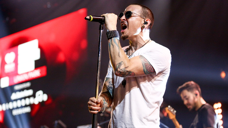 Chester Bennington wearing sunglasses and performing on stage with Linkin Park